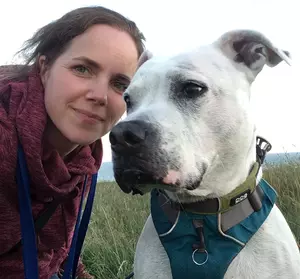 Claire Stallard - Behaviour and Training Development Manager at Blue Cross with white Staffordshire bull terrier