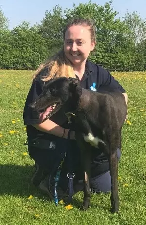 Amy Harris, Apprentice Animal Welfare Assistant, kneeling next to dog